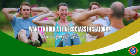 A woman taking part in an outdoors exercise class. She's sitting on the grass doing a sit up.